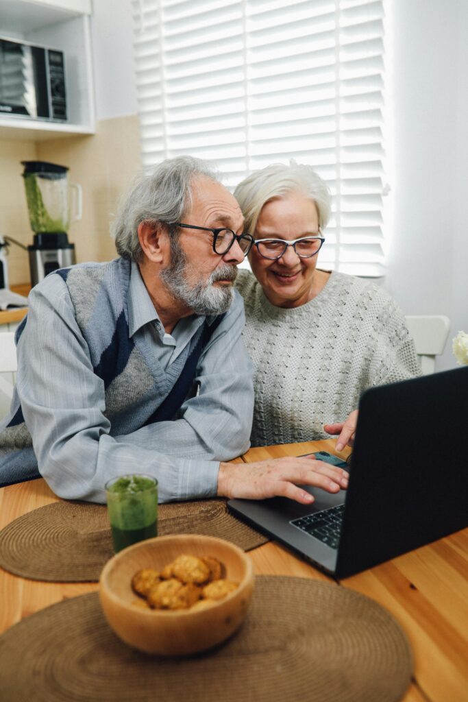 An elderly couple using a laptop