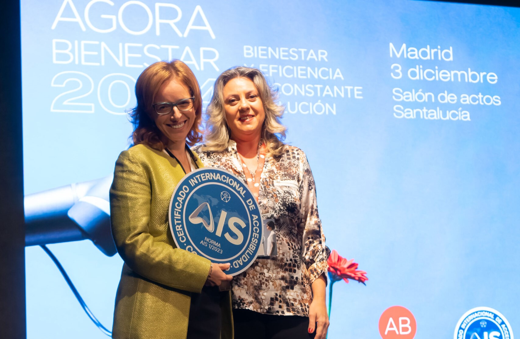 Esther Bienes entrega la placa a la directora de Ágora Bienestar